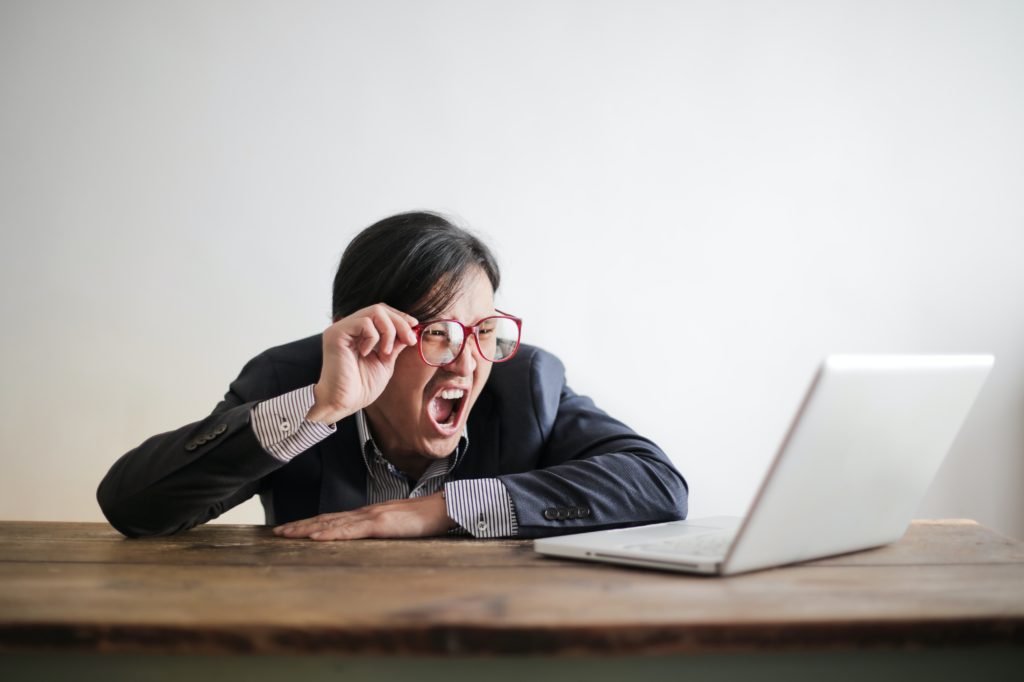 stressed person looking at laptop 