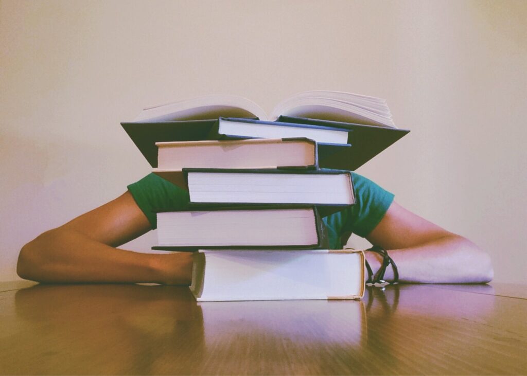 a pax hidden behind a pile of books